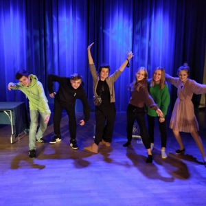 Szóstka laureatów z Małej Akademii na scenie WDK oświetlonej na niebiesko. Prezentują się do zdjęcia w dynamicznych, teatralnych pozach.
